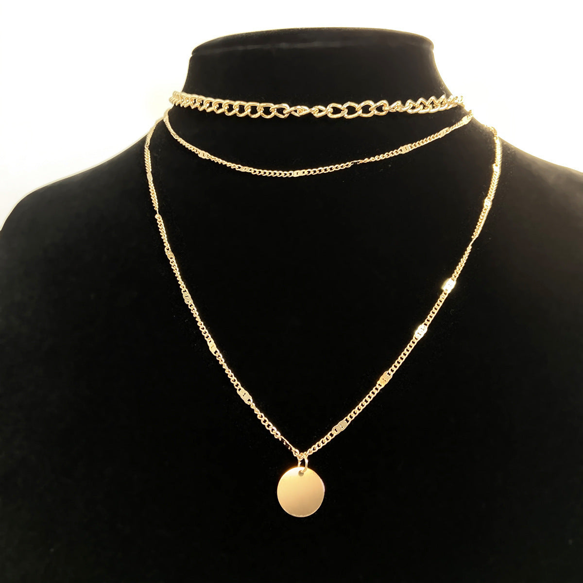 Fashionable gold-tone disc pendant necklace designed to rest on the collarbone.