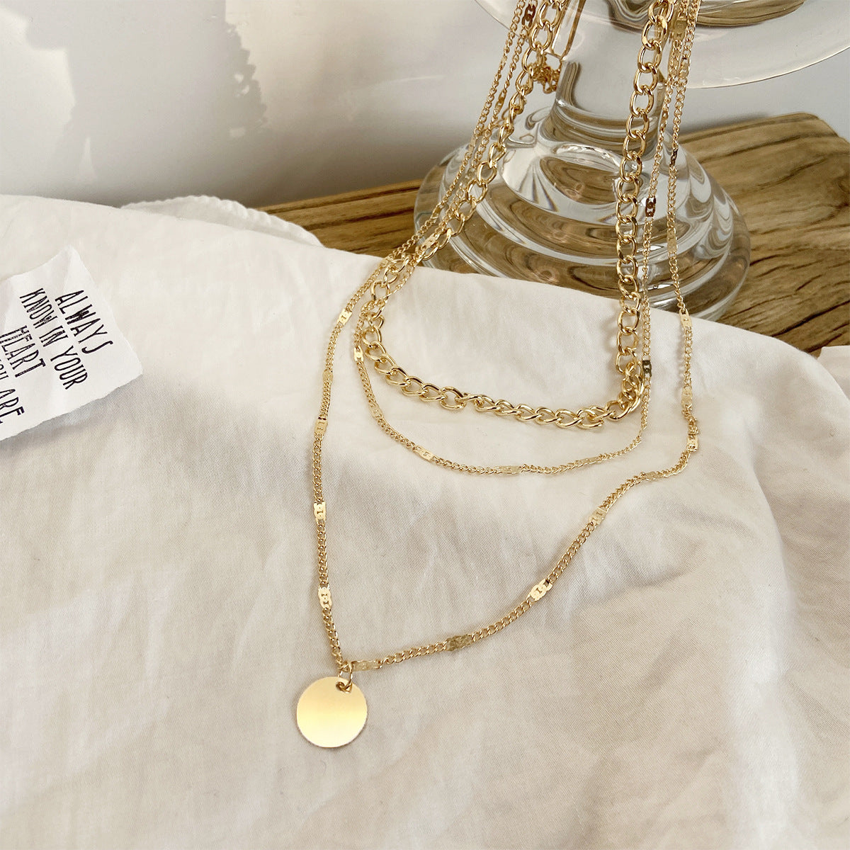 Chic and modern women’s necklace with gold disc details and fine chain layers.